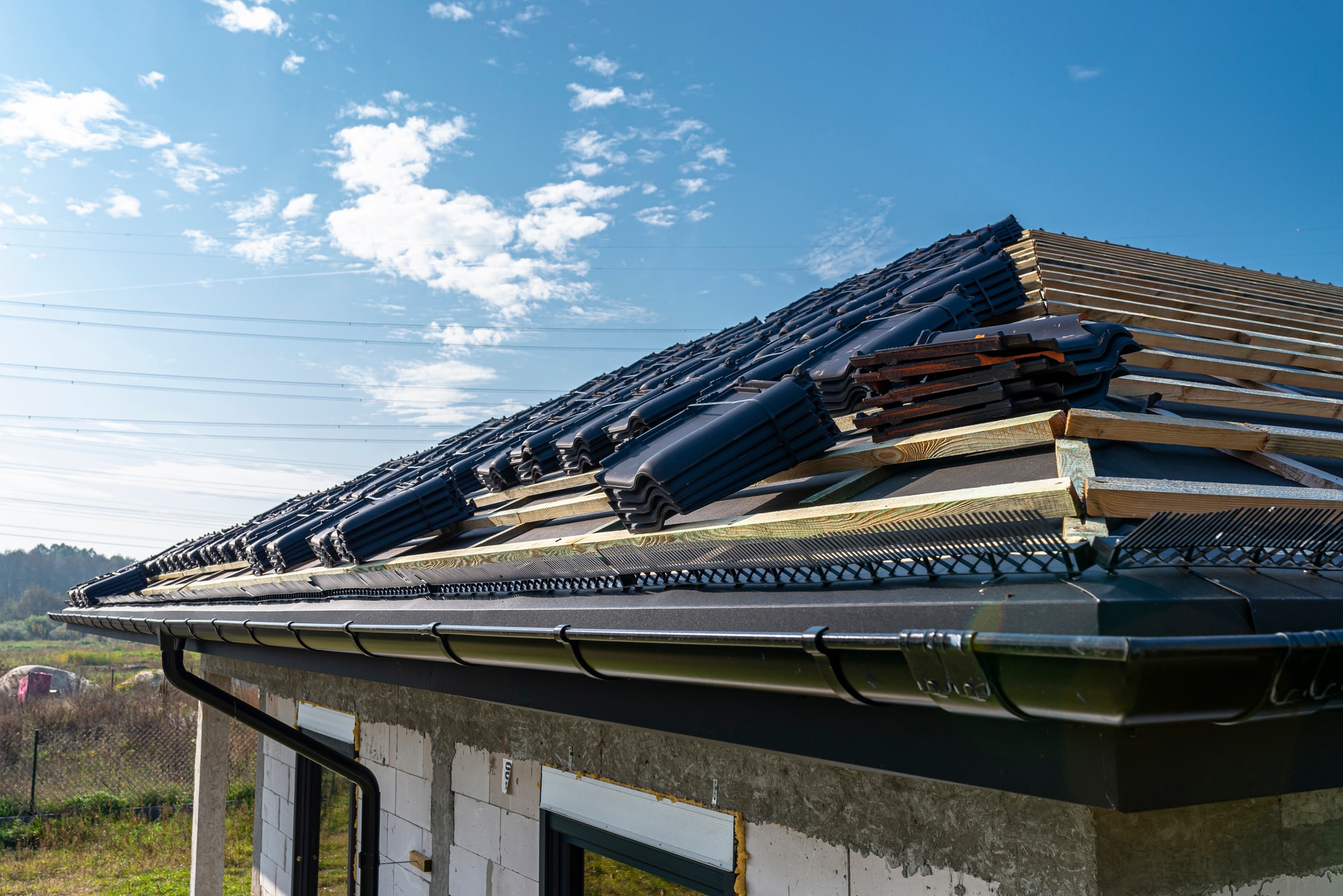 Roof ceramic tile arranged in packets on the roof on roof battens. Preparation for laying roof tiles